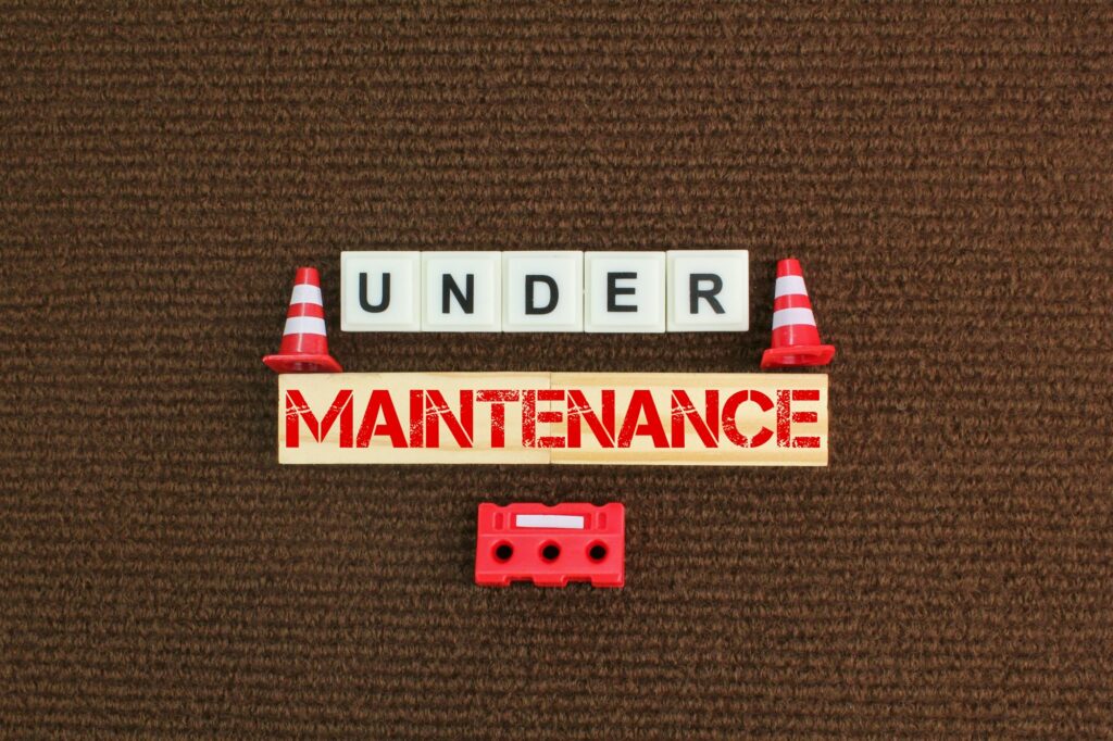 construction cones and alphabet letters with the word under maintenance